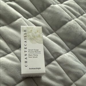Chantecaille White Face Serum Box on Gray Quilted Bedding